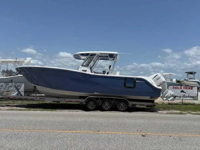 Slide: The Image of 2025 Sea Fox 328 Commander boat on trailer, parked roadside under clear sky. - 2