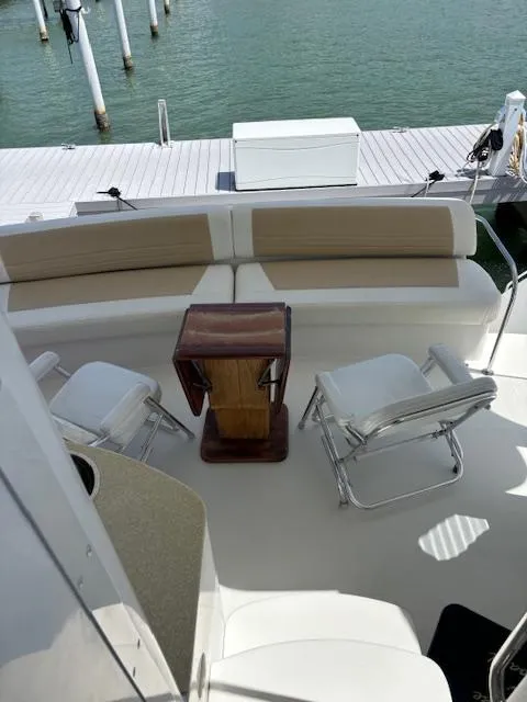 Slide: The Image of 2006 Carver 43 Motor Yacht deck with seating and table, docked by the water. - 17