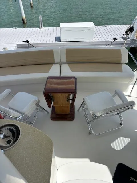Slide: The Image of 2006 Carver 43 Motor Yacht interior with seating and table, docked by the water. - 18