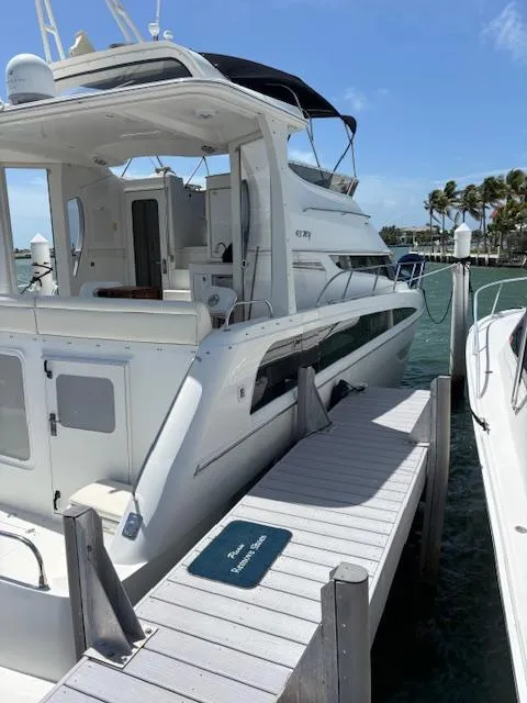 Slide: The Image of 2006 Carver 43 Motor Yacht docked at marina, sunny day, clear skies, palm trees in background. - 21