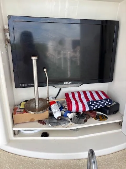 Slide: The Image of 2006 Carver 43 Motor Yacht interior with TV, American flag, and assorted items on shelf. - 24