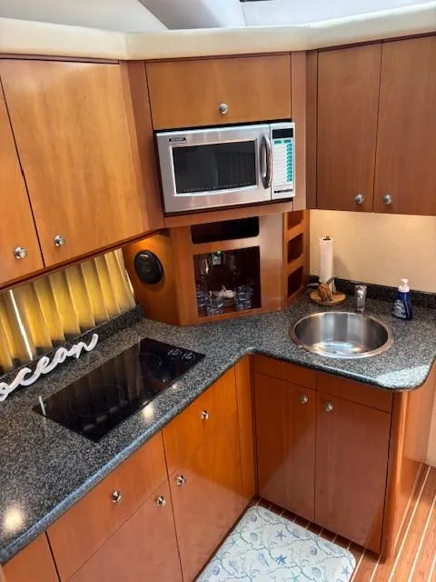 Slide: The Image of 2006 Carver 43 Motor Yacht kitchen with microwave, sink, and stovetop. - 31