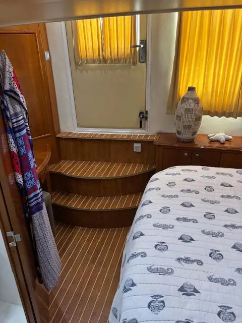 Slide: The Image of Interior of 2006 Carver 43 Motor Yacht with wooden steps and nautical-themed bedding. - 46