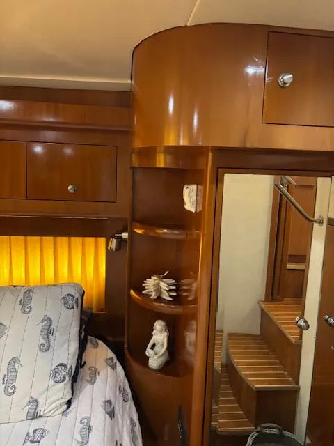 Slide: The Image of Luxurious 2006 Carver 43 Motor Yacht interior with wooden cabinetry and cozy bedroom. - 49