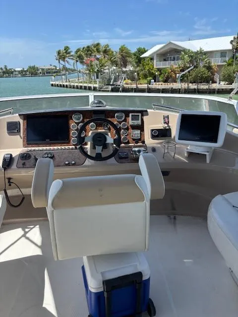 Slide: The Image of Helm of 2006 Carver 43 Motor Yacht with navigational equipment, overlooking a scenic waterfront. - 12