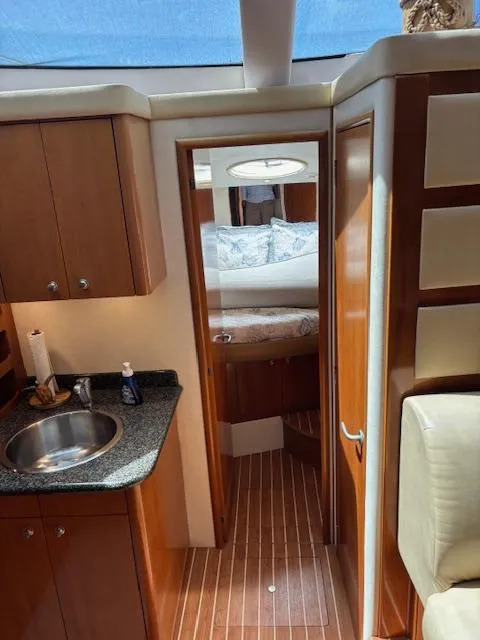 Slide: The Image of 2006 Carver 43 Motor Yacht interior with wood cabinetry, sink, and cozy bedroom. - 32