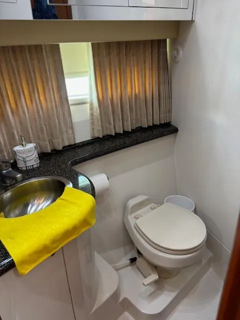 Slide: The Image of 2006 Carver 43 Motor Yacht bathroom with sink, toilet, and window with curtains. - 34