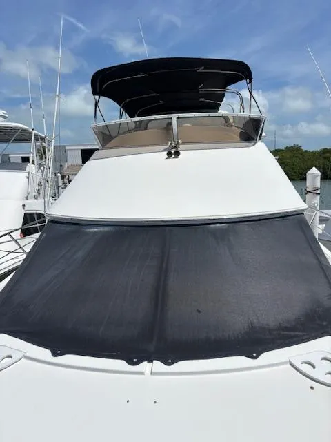 Slide: The Image of 2006 Carver 43 Motor Yacht with black sunshade, docked under blue sky. - 6