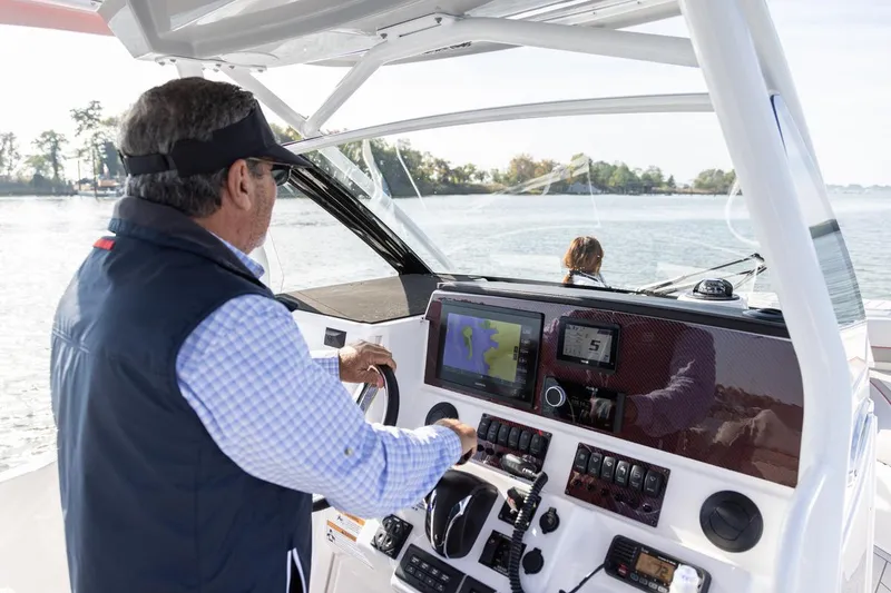 Slide: The Image of Man steering 2026 Solara S-250 CW boat on a sunny day, using navigation system. - 4