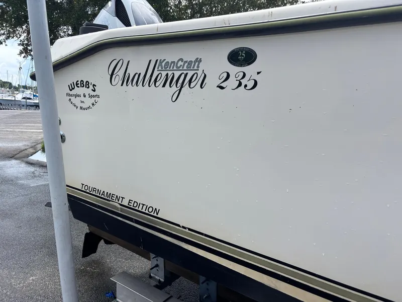 Slide: The Image of 2003 KenCraft 235 Challenger boat, Tournament Edition, parked near a marina. - 10