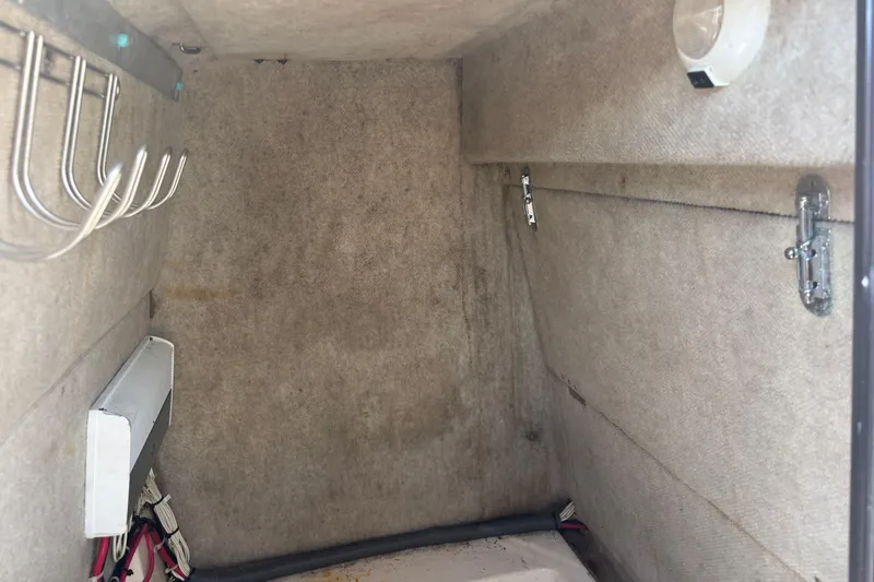 Slide: The Image of Interior cabin of 2003 KenCraft 235 Challenger boat, featuring storage hooks and wiring. - 16