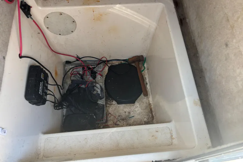 Slide: The Image of Storage compartment of a 2003 KenCraft 235 Challenger boat with wiring and tools. - 17
