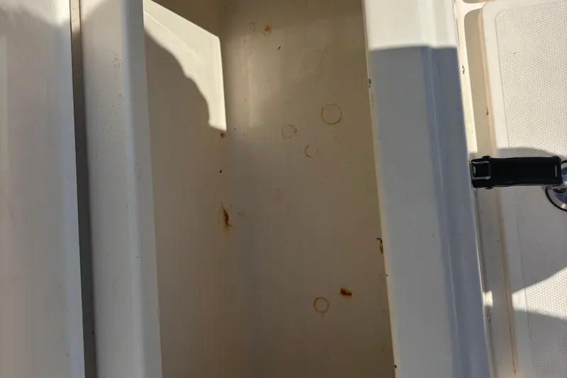 Slide: The Image of Storage compartment of 2003 KenCraft 235 Challenger boat, showing interior stains and latch. - 26
