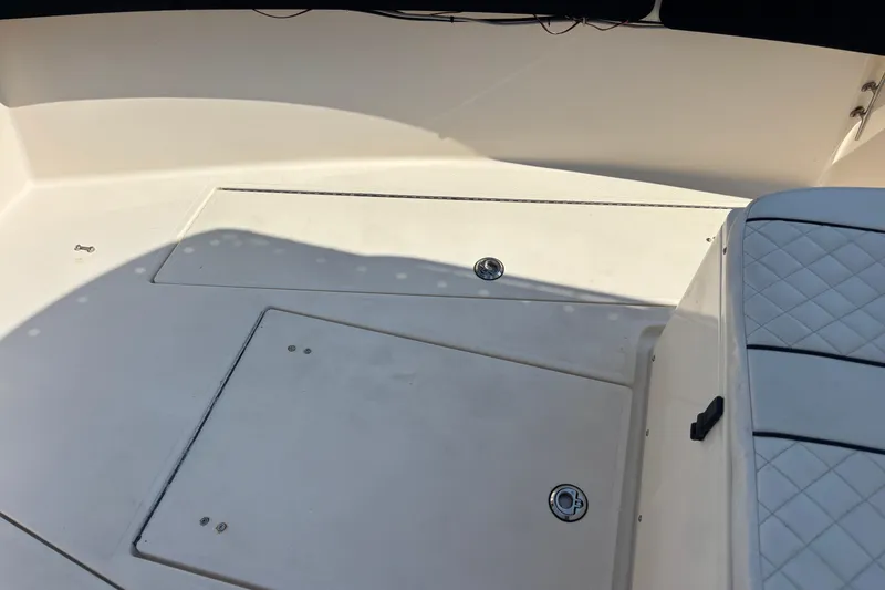 Slide: The Image of 2003 KenCraft 235 Challenger boat interior with white seating and storage compartments. - 70