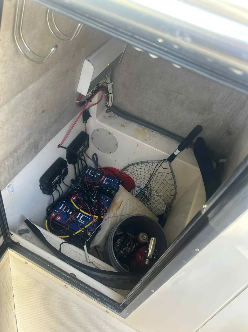 Slide: The Image of Storage compartment of a 2003 KenCraft 235 Challenger boat with batteries and fishing gear. - 8