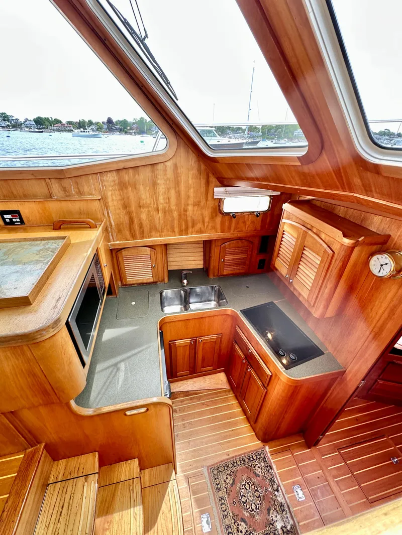Slide: The Image of 2002 Sabreline 36 Flybridge yacht interior with wooden cabinetry and modern kitchen amenities. - 16