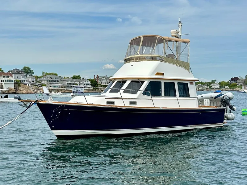 Slide: The Image of 2002 Sabreline 36 Flybridge boat anchored in scenic harbor. - 2