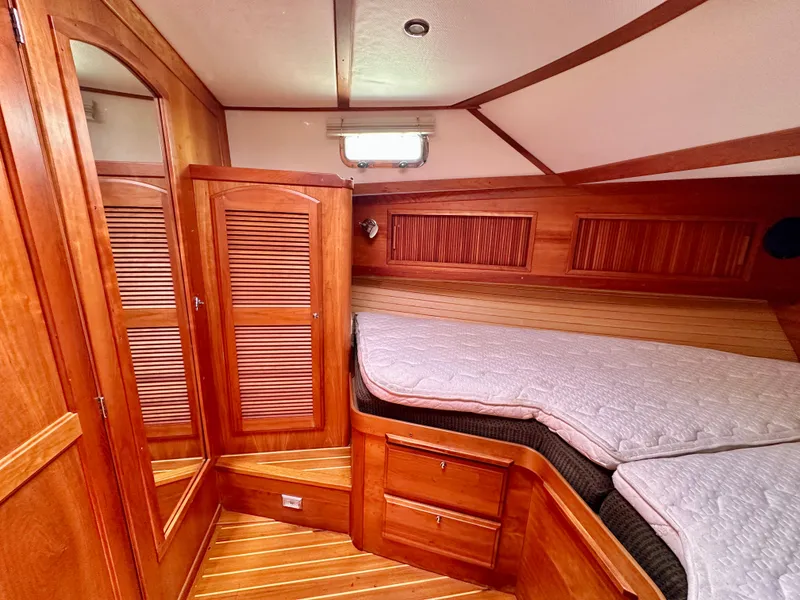 Slide: The Image of 2002 Sabreline 36 Flybridge cabin with wooden interior and cozy bedding. - 21