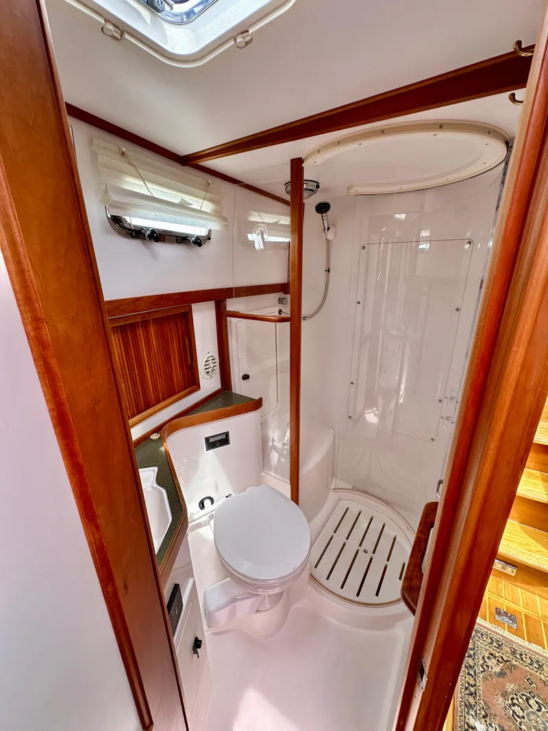 Slide: The Image of 2002 Sabreline 36 Flybridge bathroom with shower, toilet, and wooden accents. - 25