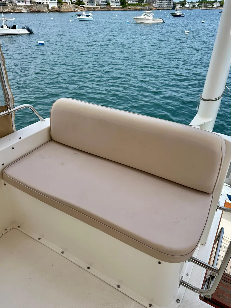 Slide: The Image of 2002 Sabreline 36 Flybridge boat with beige seating, overlooking a serene waterfront. - 32
