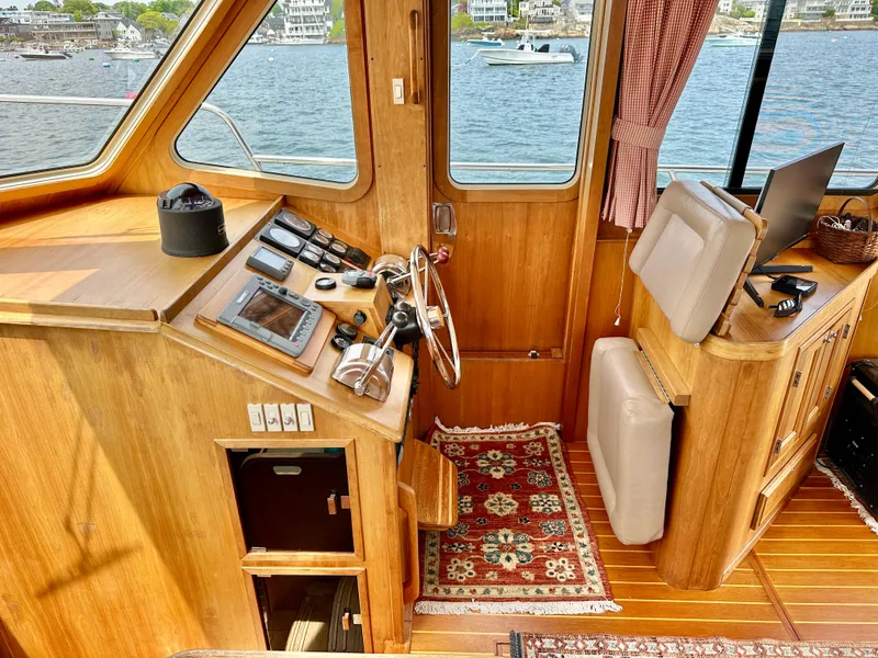 Slide: The Image of 2002 Sabreline 36 Flybridge interior with helm, wooden finish, and nautical instruments. - 13