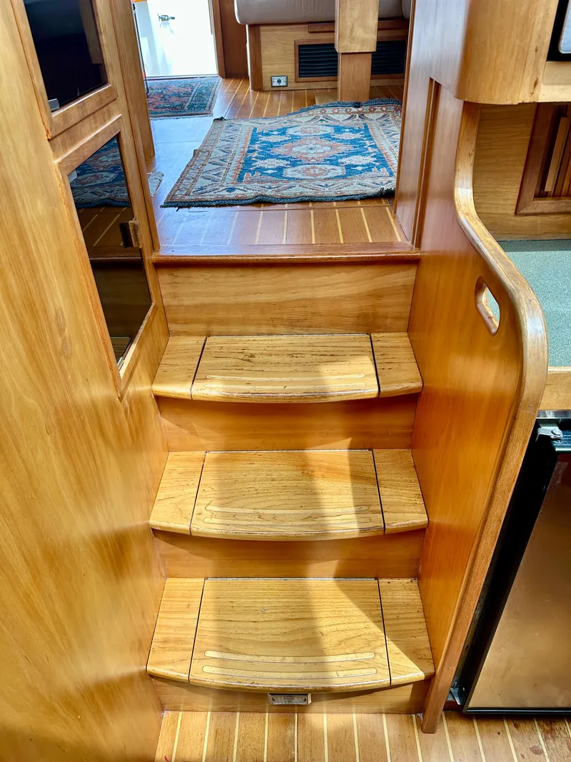 Slide: The Image of Wooden stairs inside 2002 Sabreline 36 Flybridge yacht, featuring elegant design and carpeted flooring. - 17