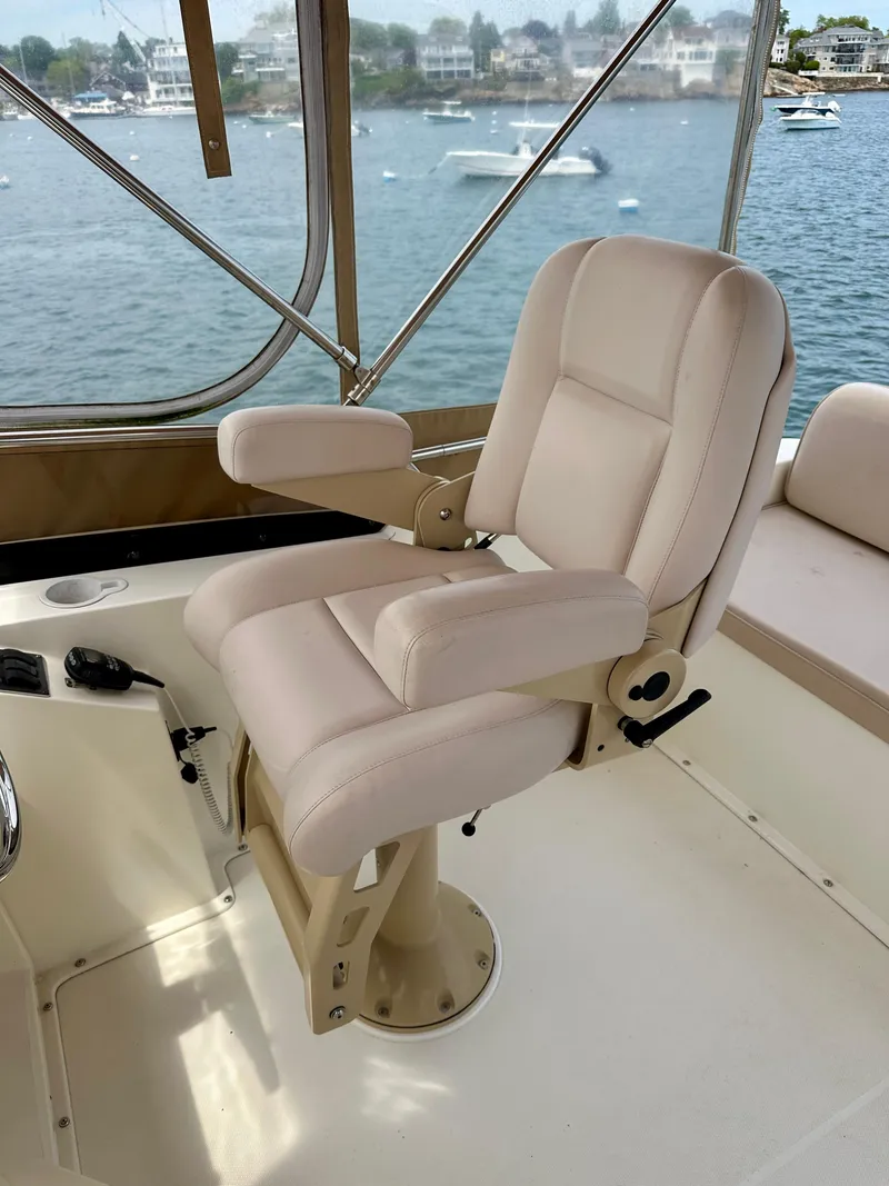 Slide: The Image of Captain's chair on 2002 Sabreline 36 Flybridge, overlooking serene waterfront. - 34