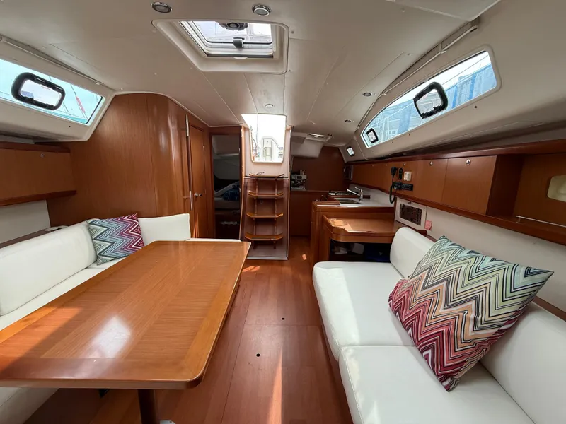 Slide: The Image of Interior of 2008 Beneteau Oceanis 40 yacht with wood finish and colorful cushions. - 24