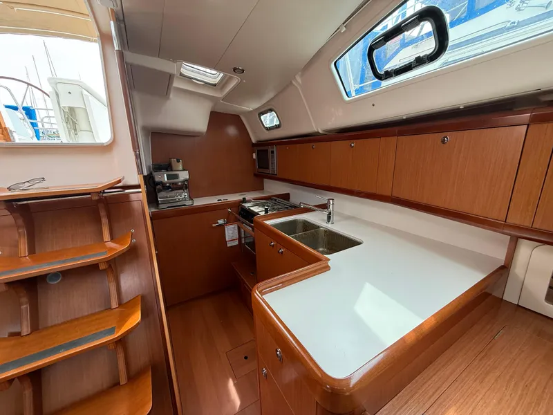 Slide: The Image of Interior of 2008 Beneteau Oceanis 40 yacht kitchen with wood cabinetry and modern appliances. - 32