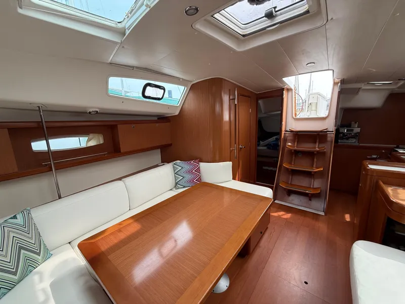 Slide: The Image of Interior of 2008 Beneteau Oceanis 40 sailboat with wooden furnishings and white seating. - 38