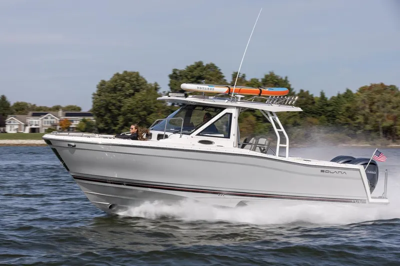 The Image of 2026 Solara S-310 CW boat cruising on a lake with trees in the background. - 1