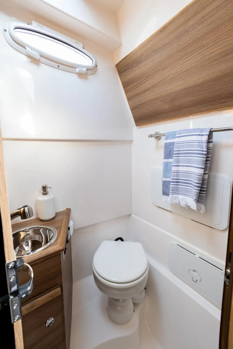 Slide: The Image of Compact bathroom in 2026 Solara S-310 CW boat with sink, toilet, and window. - 12