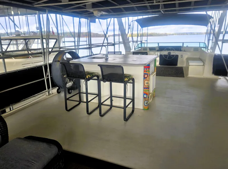 Slide: The Image of 1996 Sumerset 82'x 18' Widebody Houseboat interior with bar stools and lake view. - 11