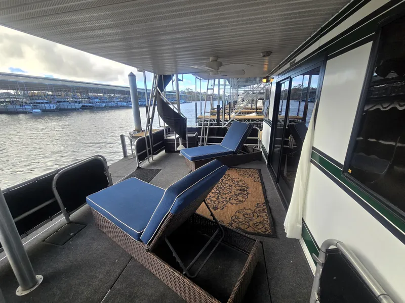 Slide: The Image of 1996 Sumerset 82'x 18' Widebody Houseboat with deck chairs and lake view. - 12
