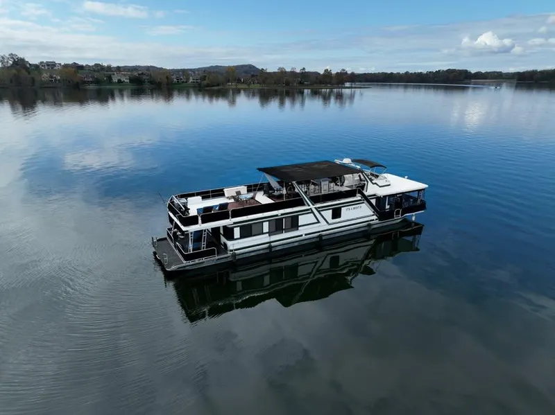 Slide: The Image of 1996 Sumerset 82'x 18' Widebody Houseboat on a calm lake. - 2