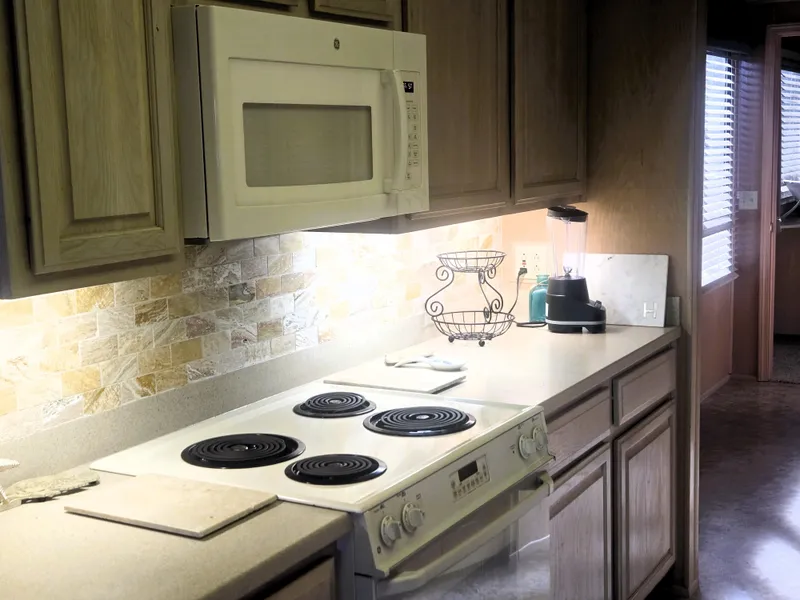 Slide: The Image of Kitchen interior of 1996 Sumerset 82'x 18' Widebody Houseboat with stove and microwave. - 22