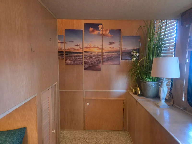 Slide: The Image of Interior of 1996 Sumerset houseboat with ocean artwork, potted plant, and lamp. - 36