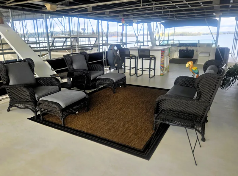 Slide: The Image of Luxurious 1996 Sumerset 82'x 18' Widebody Houseboat interior with wicker furniture and lake view. - 8