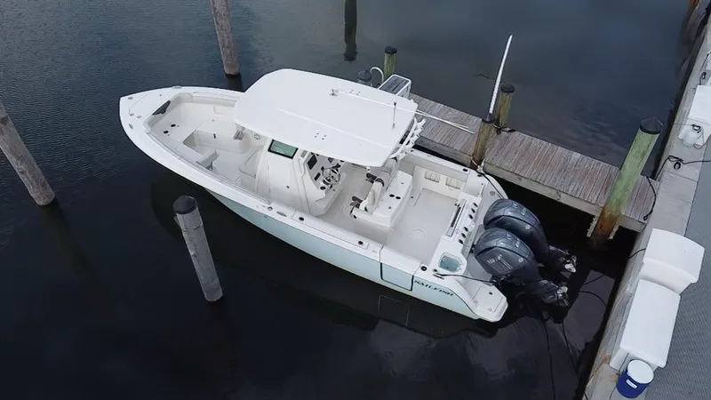 Slide: The Image of 2019 Sailfish 270 boat docked, featuring dual outboard motors and spacious deck. - 4