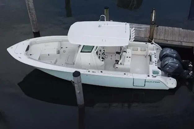 Slide: The Image of 2019 Sailfish 270 boat docked, featuring dual outboard motors and spacious deck. - 6