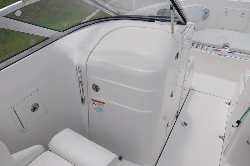 Slide: The Image of 2008 Wellcraft 220 Sportsman boat interior with white seating and storage compartments. - 7