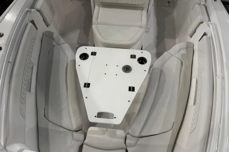 Slide: The Image of 2026 Tidewater 256 CC Adventure boat interior with white seating and table. - 12