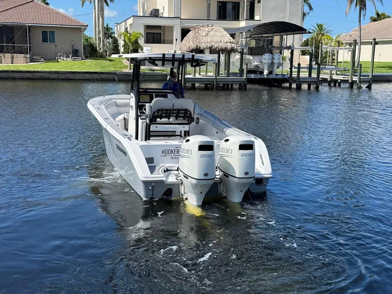 Slide: The Image of 2020 Sea Pro 259 Center Console boat with twin Suzuki engines on a calm waterway. - 10
