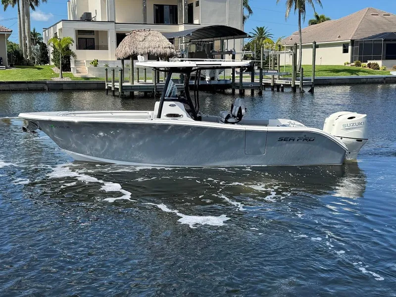 Slide: The Image of 2020 Sea Pro 259 Center Console boat on calm water near waterfront homes. - 13
