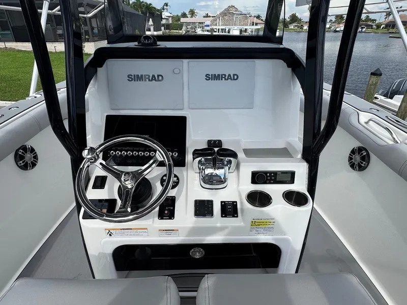 Slide: The Image of 2020 Sea Pro 259 Center Console boat dashboard with steering wheel and Simrad displays. - 17