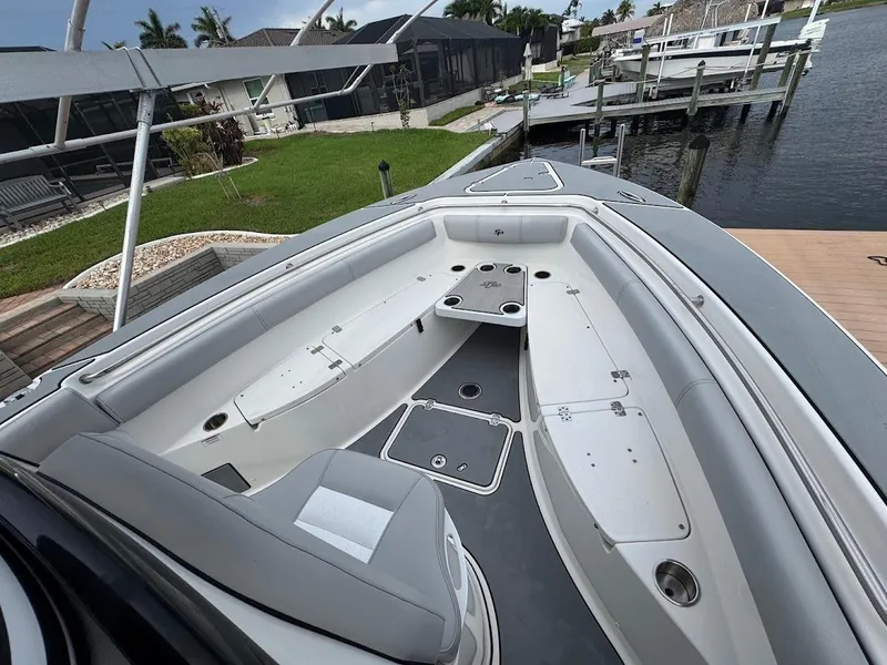 Slide: The Image of 2020 Sea Pro 259 Center Console boat interior with seating and storage, docked by a waterfront. - 24