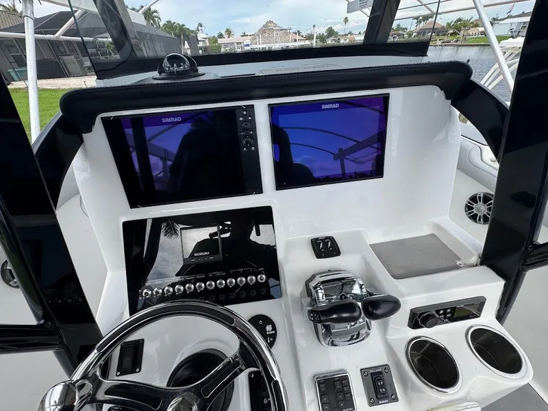 Slide: The Image of 2020 Sea Pro 259 Center Console boat dashboard with dual Simrad displays and controls. - 25