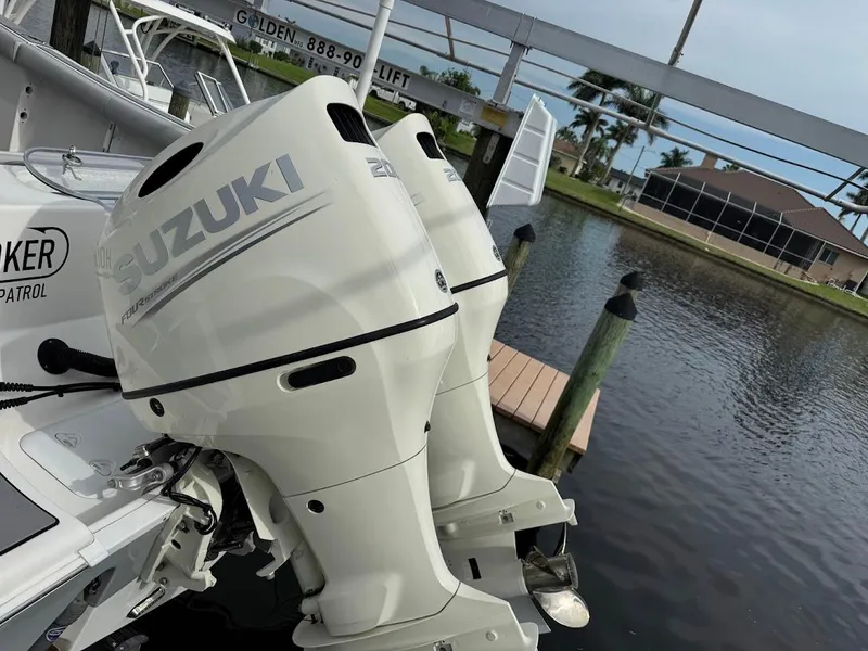 Slide: The Image of Twin Suzuki outboard engines on a 2020 Sea Pro 259 Center Console boat docked by water. - 43