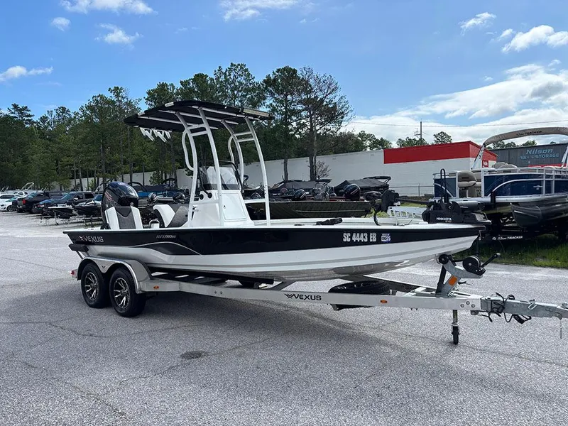 Slide: The Image of 2022 Vexus AVX1980CC boat on trailer in parking lot, surrounded by trees and other boats. - 4