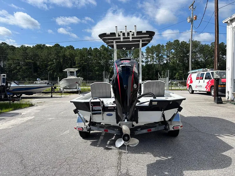 Slide: The Image of 2022 Vexus AVX1980CC boat with outboard motor on a trailer, parked outdoors. - 7